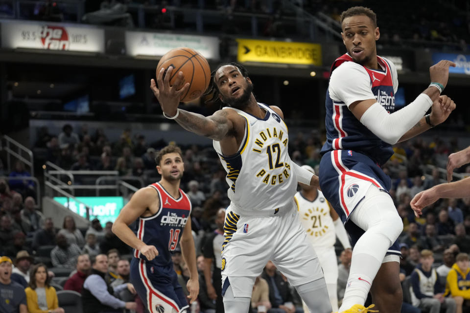 Indiana Pacers forward Oshae Brissett (12) pulls in a rebound behind Washington Wizards center Daniel Gafford (21) during the second half of an NBA basketball game in Indianapolis, Monday, Dec. 6, 2021. (AP Photo/AJ Mast)