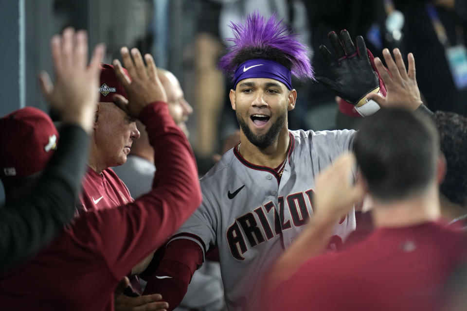 Arizona Diamondbacks' Lourdes Gurriel Jr. celebrates with teammates in the dugout after his solo home run during the sixth inning in Game 2 of a baseball NL Division Series against the Los Angeles Dodgers, Monday, Oct. 9, 2023, in Los Angeles. (AP Photo/Ashley Landis)