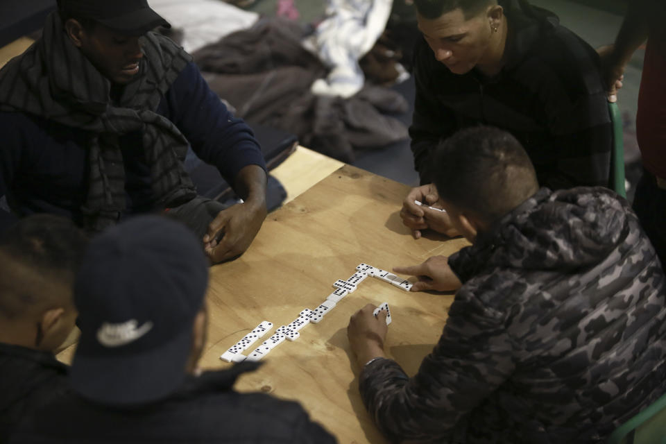 Migrants who are awaiting their chance to request asylum in the U.S. play dominos inside a shelter in Bachilleres gymnasium in Ciudad Juarez, Mexico, Tuesday, Feb. 19, 2019. Hundreds of migrants, some of whom arrived from the recently closed shelter in Piedras Negras on the Mexico-U.S. border, are camped out in the gym waiting their chance to submit their asylum request at the El Paso port of entry. (AP Photo/Christian Torres)