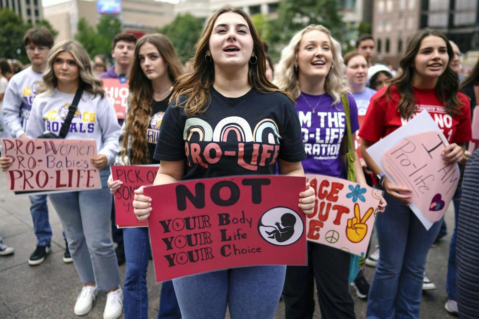 FILE - Joslynn Latynski, center, Airees Murland, second from right, and Holly McMahon, fourth from right, from Jefferson County Christian School in Wintersville, Ohio, sing during the Ohio March for Life, at the Ohio State House in Columbus, Ohio, Friday, Oct. 6, 2023. Heavier-than-normal turnout is expected Wednesday, Oct. 11, 2023, as early voting begins in Ohio's closely watched off-year election to decide the future of abortion access and marijuana legalization in the state. (AP Photo/Carolyn Kaster, File)