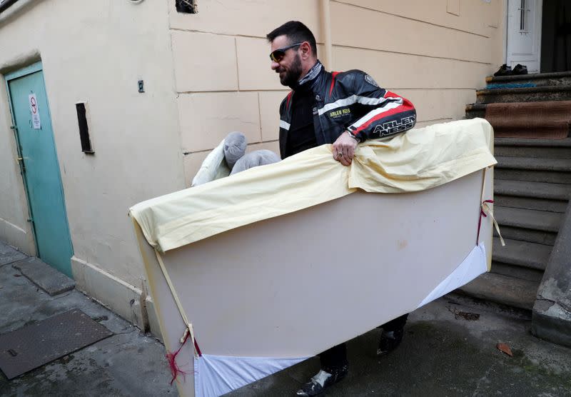 A member of the 'Easy Riders', a Hungarian bikers group, carries the belongings of a domestic violence victim in Budapest