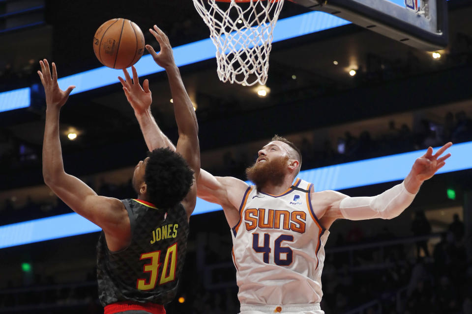 Phoenix Suns center Aron Baynes (46) battles Atlanta Hawks center Damian Jones (30) for a rebound in the first half of an NBA basketball game Tuesday, Jan. 14, 2020, in Atlanta. (AP Photo/John Bazemore)