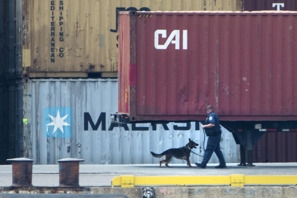 An officer with a dog inspects a container along the Delaware River in Philadelphia, Tuesday, June 18, 2019. U.S. authorities have seized more than $1 billion worth of cocaine from a ship at a Philadelphia port, calling it one of the largest drug busts in American history. The U.S. attorney’s office in Philadelphia announced the massive bust on Twitter on Tuesday afternoon. Officials said agents seized about 16.5 tons (15 metric tons) of cocaine from a large ship at the Packer Marine Terminal. (AP Photo/Matt Rourke)