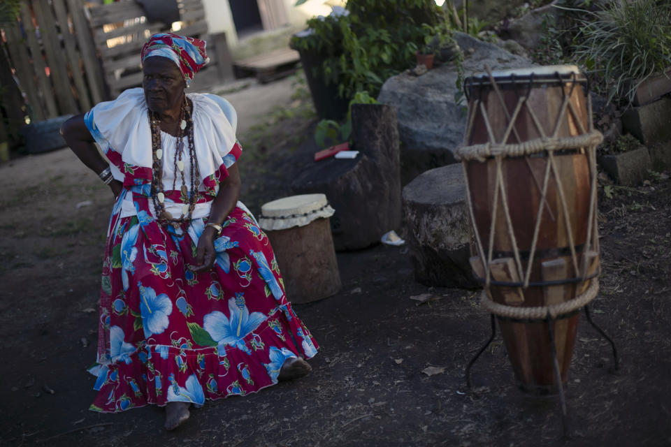 A resident waits for the arrival of King Tchongolola Tchongonga Ekuikui VI, of Angola's Bailundo kingdom, in the "Quilombo do Camorim," a community of descendants of runaway slaves, many from Angola, in Rio de Janeiro, Brazil, Wednesday, Nov. 8, 2023. (AP Photo/Bruna Prado)