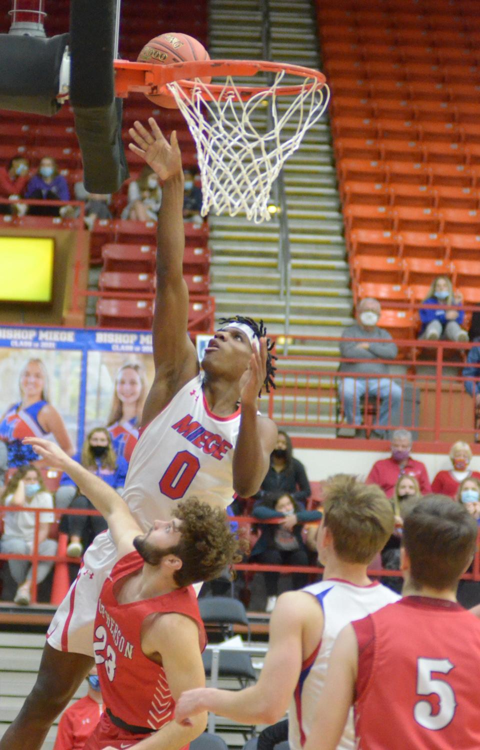 Bishop Miege’s Taj Manning (0) shoots a layup while being guarded by McPherson’s Adam Elliot (23) during the fourth period of the 4A state semifinal game.