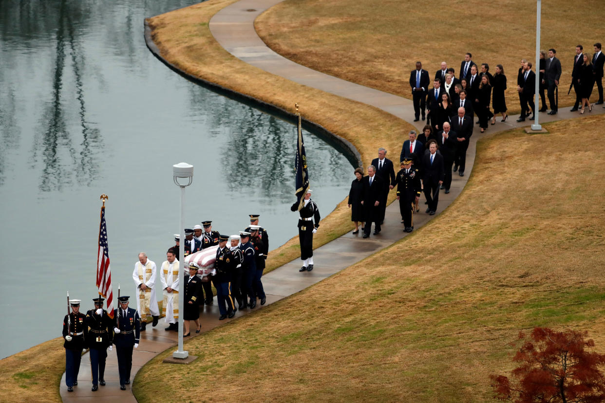 The flag-draped casket of former President George H.W. Bush is carried by a joint services military honor guard followed by family members at the George H.W. Bush Presidential Library and Museum Thursday, Dec. 6, 2018, in College Station, Texas. (Photo: Jeff Roberson/Pool via Reuters)