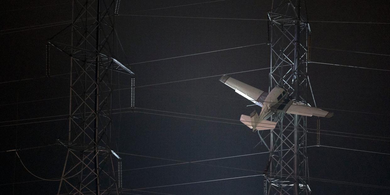 A small plane rests on live power lines after crashing on Sunday, November 27, 2022, in Montgomery Village, Maryland.