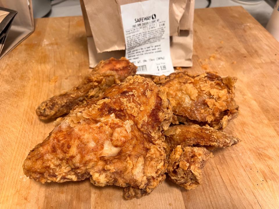 Fried chicken in front of brown safeway bag on wood block