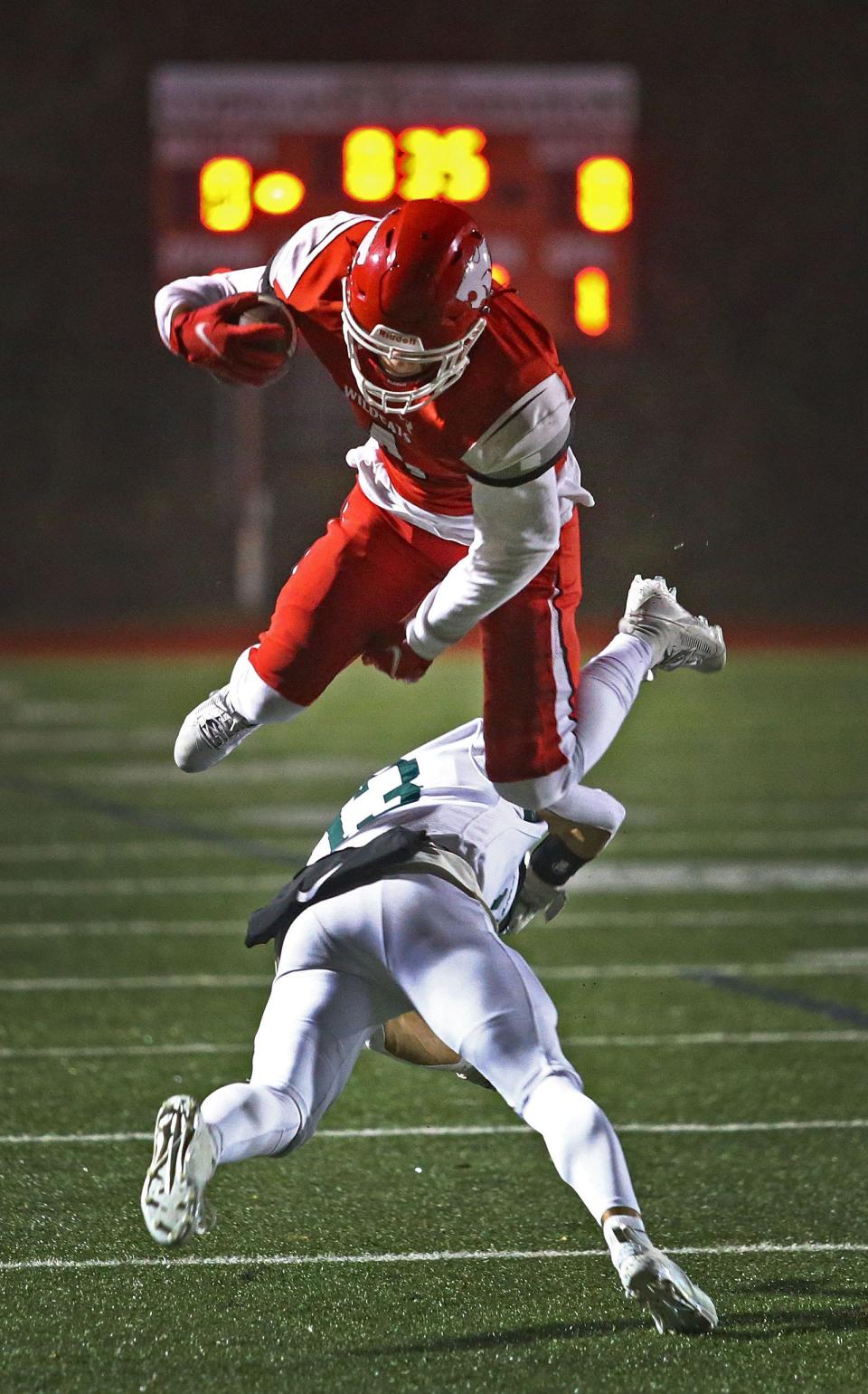 Milton wide receiver Ronan Sammon leaps over Dartmouth's Markus Andrews while trying to get into the end zone during a playoff game at Milton on Nov. 9. The Wildcats scored on the next play.
