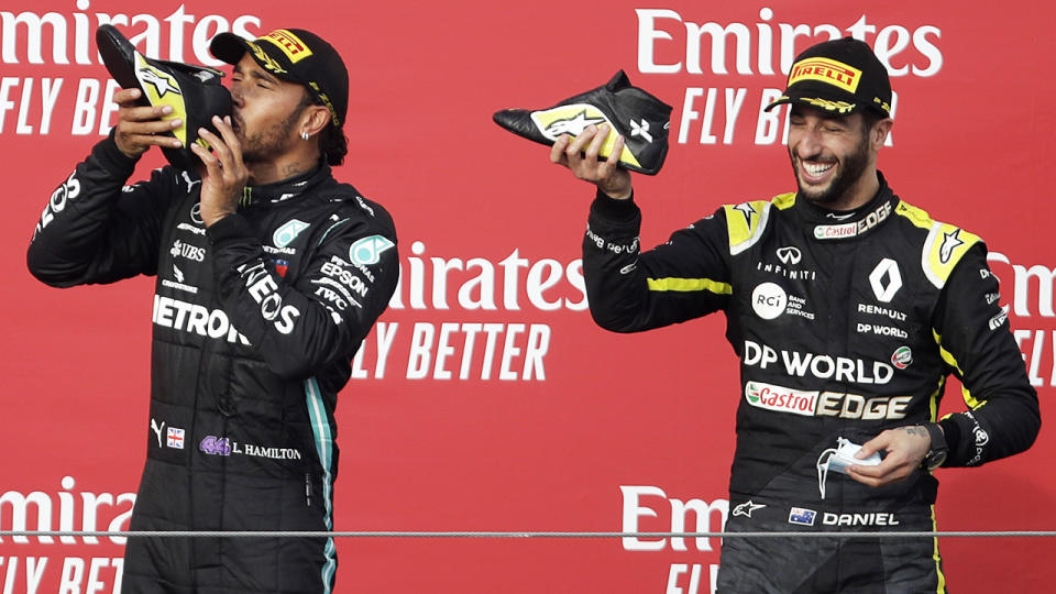 Daniel Ricciardo and Lewis Hamilton, pictured here doing a shoey.