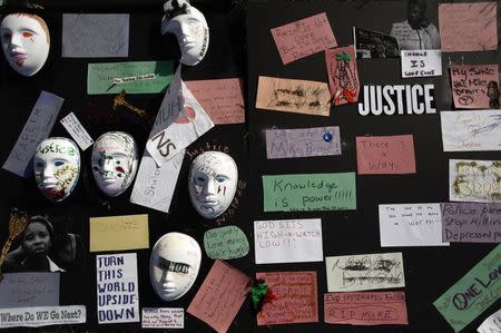 Messages written on papers and masks are displayed on a board along Canfield Drive where Michael Brown was fatally shot by a police officer in Ferguson, Missouri, August 24, 2014. REUTERS/Joshua Lott