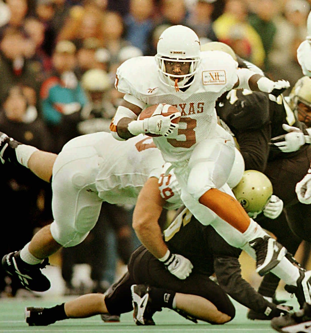 Texas running back Shon Mitchell finds running room up the middle as offensive lineman Dan Neil lays down a pancake block during a 1996 game. Neil did well in the pros but would love to have had the financial advice available to today's Longhorns.