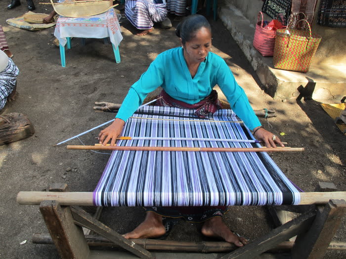 Weaving: A Lamalera woman is weaving in front of her house in the village. (