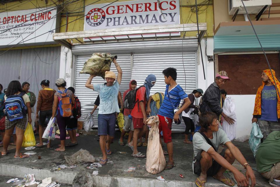 Residents take sacks of medical items after super typhoon Haiyan hit Tacloban