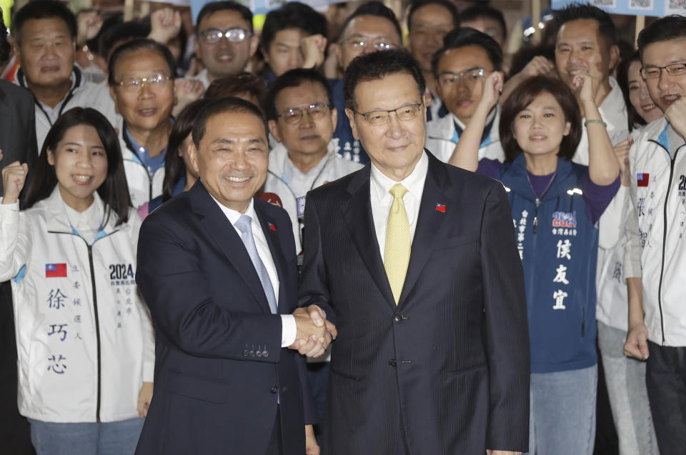 Taiwan's Nationalist Party presidential candidate Hou Yu-ih, center left, and his vice president candidate Chao Shao-kang pose for the media outside of Central Election Commission in Taipei, Taiwan, Friday, Nov. 24, 2023. (AP Photo/ Chiang Ying-ying)