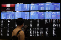 A TV crew films the blank stock board at Tokyo Stock Exchange Thursday, Oct. 1, 2020, in Tokyo. The Tokyo Stock Exchange temporarily suspended all trading due to system problem. (AP Photo/Eugene Hoshiko)