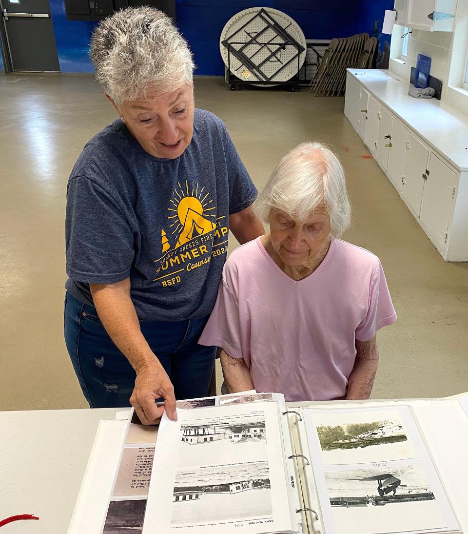 Bonnet Shores Fire District Councilwoman Carolyn DiLeo, left, goes over historic Bonnet Shores photos with resident historian Lee Listro. DiLeo is also the chair of the History Committee.