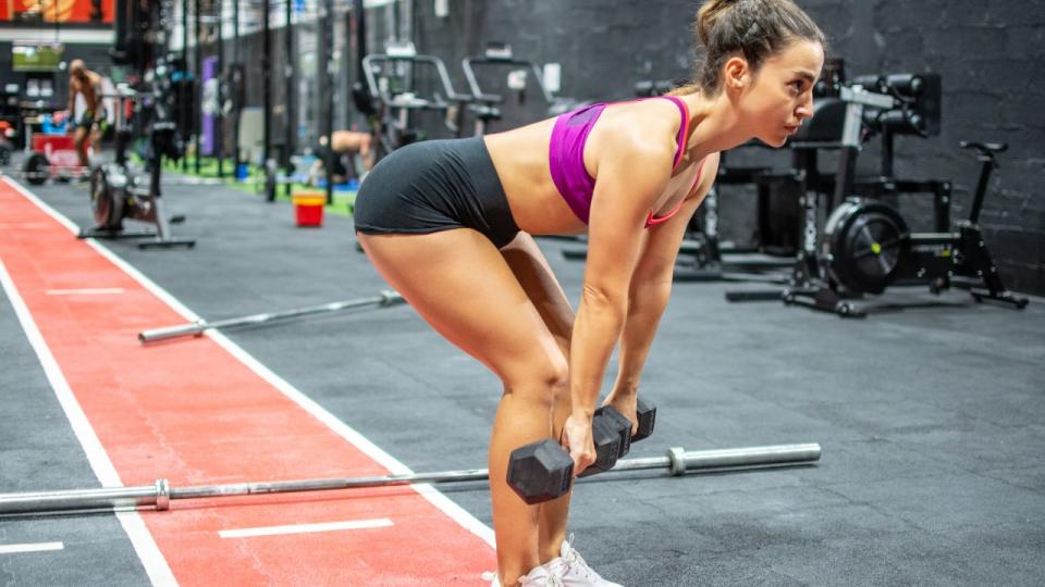 Woman performs dumbbell Romanian deadlift