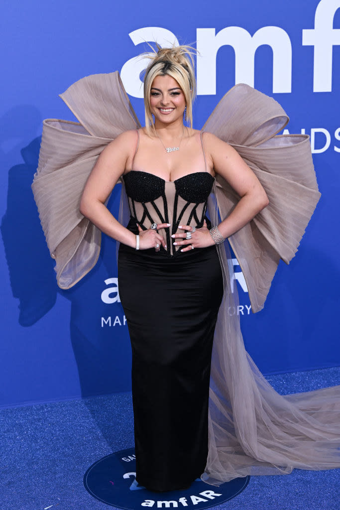 Bebe is wearing column dress with a sweetheart neckline paired with a gigantic bow on her back