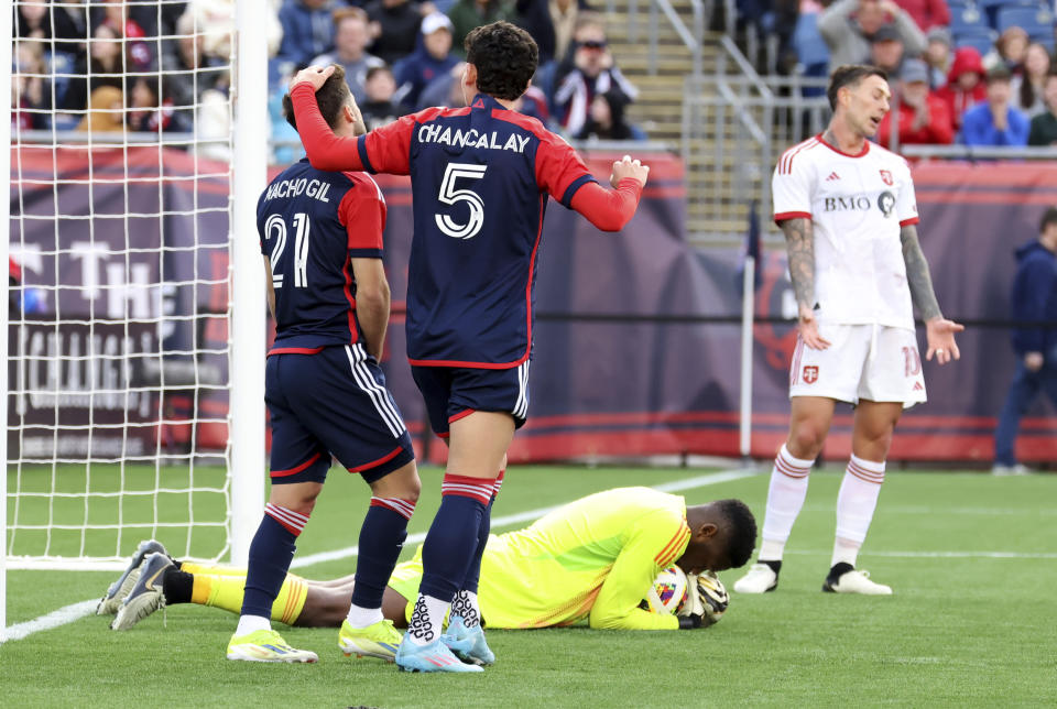 New England Revolution midfielder Nacho Gil (21) and New England Revolution forward Tomas Chancalay (5) react to a missed goal in the second half of an MLS soccer match, Sunday, March 3, 2024, in Foxborough, Mass. Toronto FC goalkeeper Sean Johnson cradles the ball after the save. (AP Photo/Mark Stockwell)