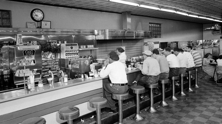 people sitting at 1950s diner 