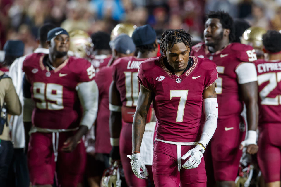 Florida State's Destyn Hill (7) and teammates return to the bench as quarterback Jordan Travis is taken off the field after being injured during the first half of an NCAA college football game against North Alabama, Saturday, Nov. 18, 2023, in Tallahassee, Fla. (AP Photo/Colin Hackley)