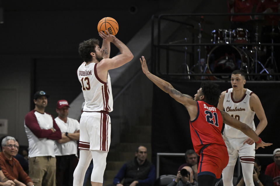 Charleston forward Ben Burnham (13) attempts a three point basket against Stony Brook guard Andre Snoddy (21) during the first half of an NCAA college basketball game in the championship of the Coastal Athletic Association conference tournament, Tuesday, March 12, 2024, in Washington. (AP Photo/Terrance Williams)