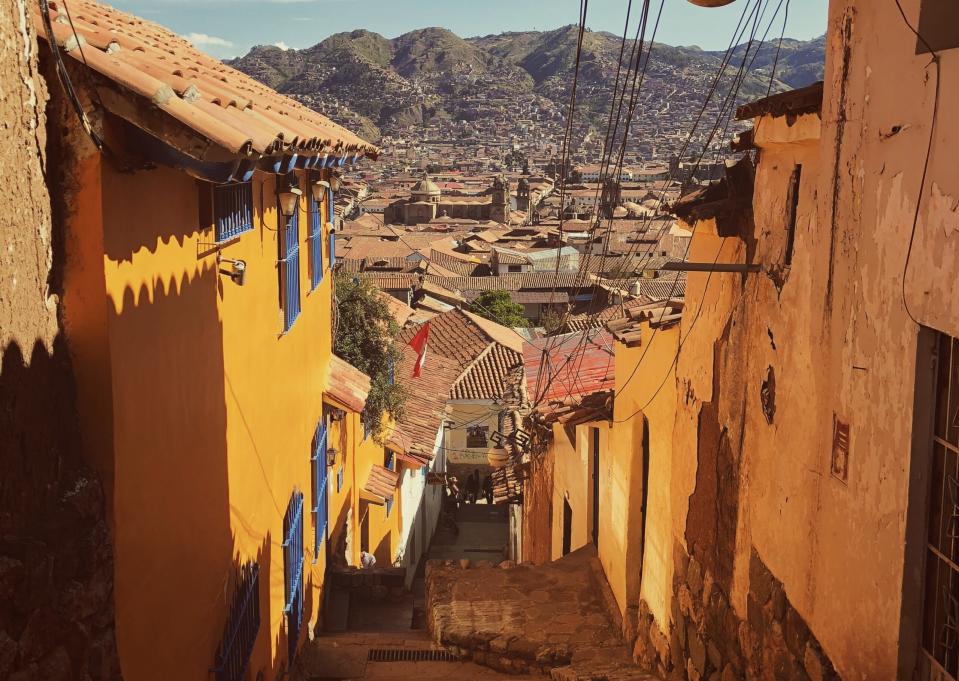 The safety of travelers in Peru is dependent on the area they stay in. 
Pictured: Cusco, Peru with winding alleys and towering mountains 