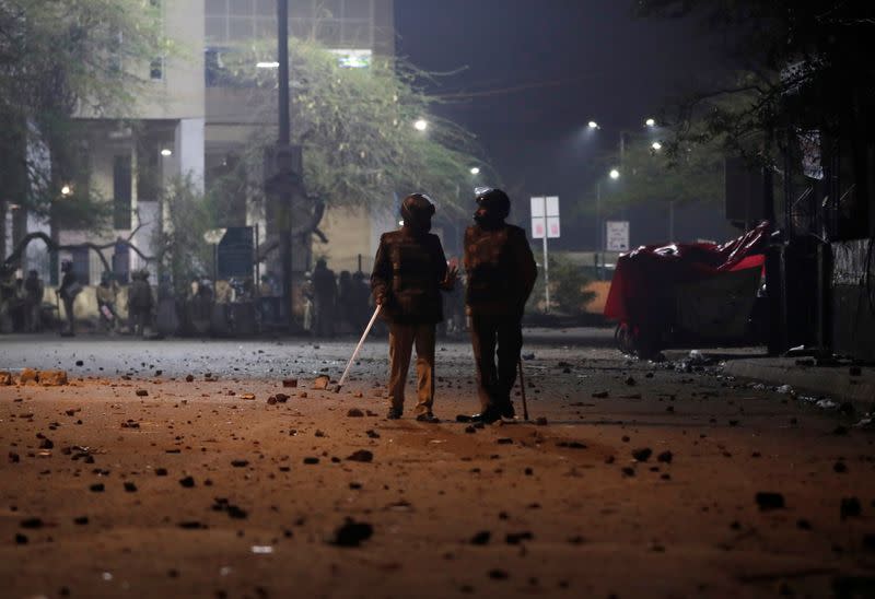 Policemen stand outside the Jamia Milia University following a protest against a new citizenship law, in New Delhi