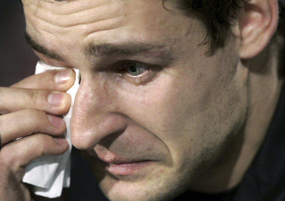 FILE - Detroit Red Wings' Jiri Fischer, of the Czech Republic, wipes tears away during a news conference in Detroit on Dec. 12, 2005. The horror that swept across the NFL when Buffalo Bills defensive back Damar Hamlin collapsed and went into cardiac arrest during a game this week in Cincinnati was all too familiar to members of the hockey community.. (AP Photo/Paul Sancya, File)