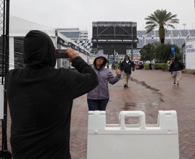 Race fans capture a rainy moment just inside the FanZone at Daytona International Speedway on Sunday, Feb. 18, 2024. The Daytona 500 was postponed until Monday at 4 p.m.