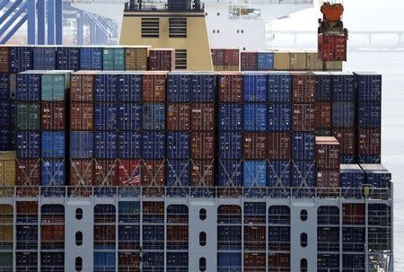 A crane carries a container (top R) from a ship at the PNC container terminal at the Busan New Port in Busan, about 420 km (261 miles) southeast of Seoul, in this file photo taken on August 8, 2013. REUTERS/Lee Jae-Won