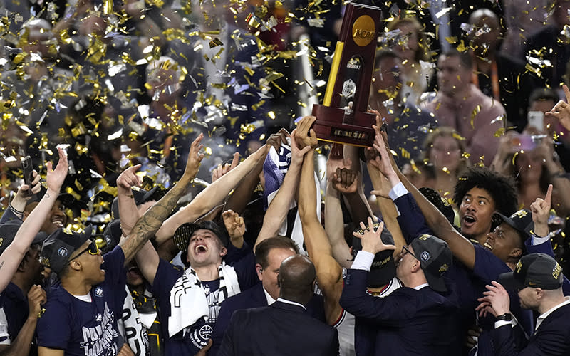 Connecticut players raise a trophy after their win over San Diego State in the men's national championship college basketball game