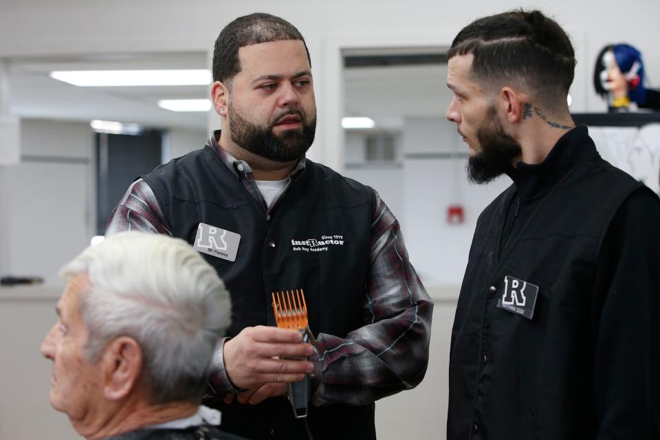 Arthur Pereira, instructor, shows Nathan Dorego the best way of holding the clippers at the Rob Roy Academy in Fall River.