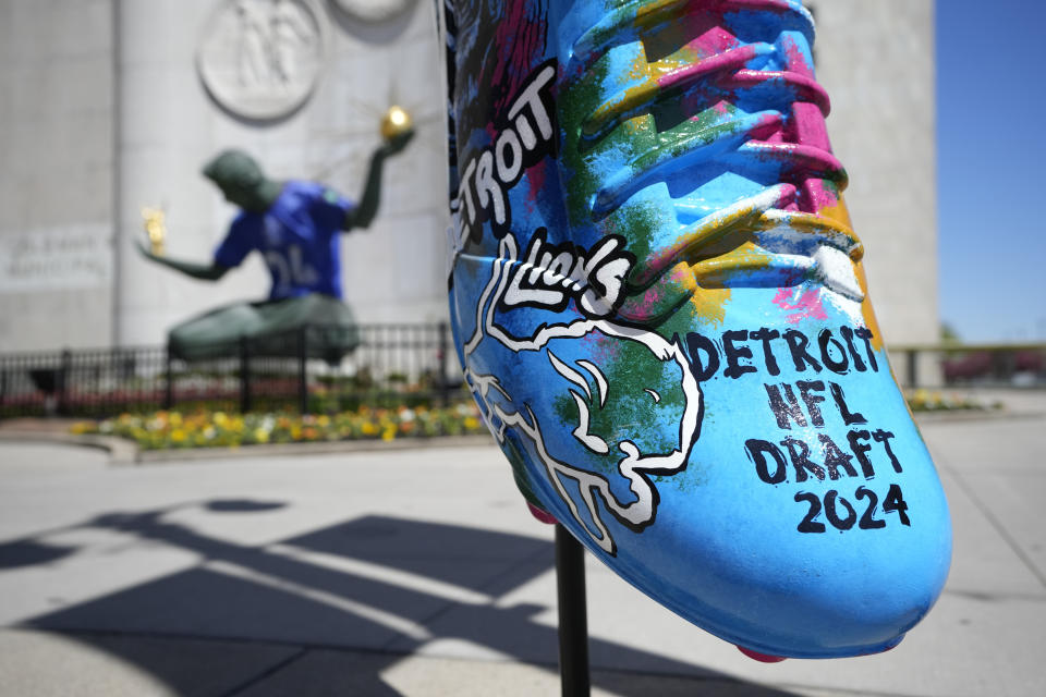 An NFL football draft cleat is displayed near the Spirit of Detroit statue, Friday, April 19, 2024, in Detroit. The draft has taken the show on the road for a decade, giving cities a chance around the country a chance to be in the spotlight. (AP Photo/Carlos Osorio)