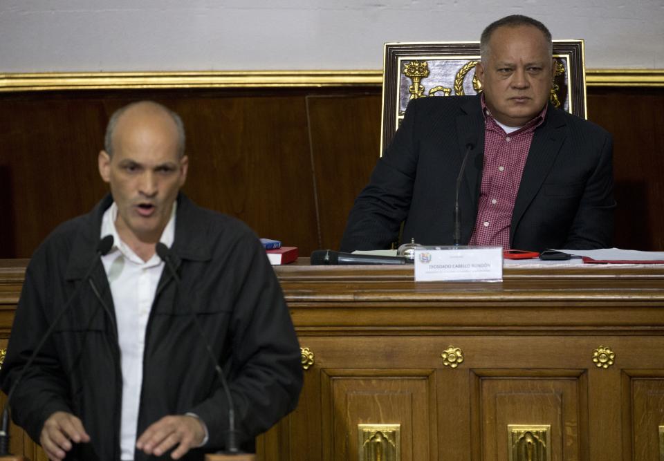 Diosdado Cabello, Venezuela's socialist party boss and president of the National Constituent Assembly, sits in the Speaker's chair as Venezuela's Planning Minister Ricardo Melendez, addresses delegates during a session in Caracas, Venezuela, Tuesday, April 2, 2019. Lawmakers loyal to President Nicolas Maduro considered whether to strip National Assembly leader Juan Guaido of immunity on Tuesday in a move that would pave the way to prosecute and potentially arrest him for allegedly violating the constitution after declaring himself interim president. (AP Photo/Ariana Cubillos)