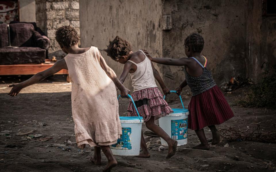 Girls carry drinking water from a well in the Kanyama compound - Simon Townsley /The Telegraph