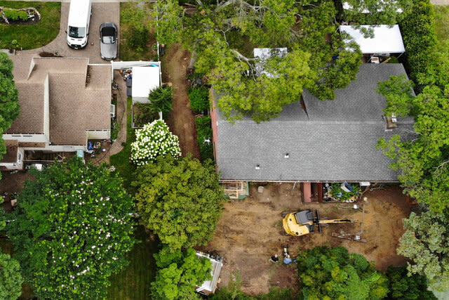 An excavator in the backyard of Rex Heuermann's home in Massapequa Park, NY.