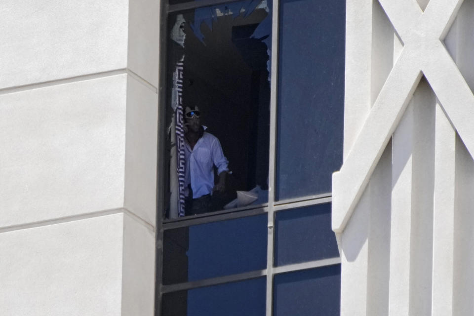 A person looks out a broken window on a hotel tower at Caesars Palace hotel-casino, Tuesday, July 11, 2023, in Las Vegas. (AP Photo/John Locher)
