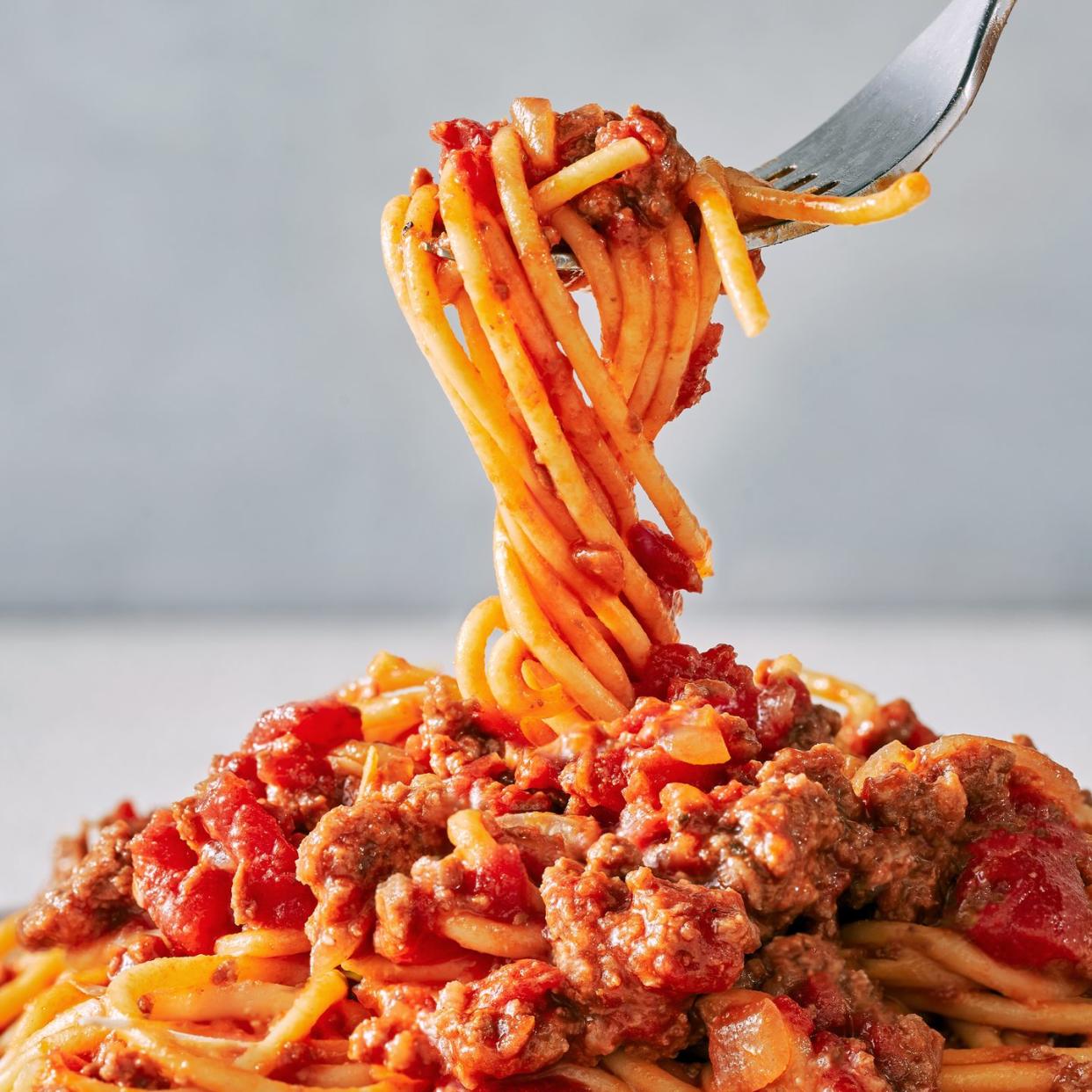 spaghetti sauce with ground beef crushed tomatoes parmesan rind and basil