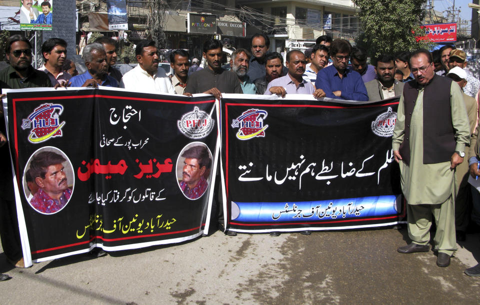 Journalists hold a banner that says, in part, 'immediately arrest the killers of journalist Aziz Memon," during a demonstration to condemn his killing, in Hyderabad, Pakistan, Monday, Feb. 17, 2020. The body of Memon was found dumped in a canal just hours after he went missing while on his way to work, police said Monday. His family said he was brutally killed but that they have no idea who was behind the slaying. (AP Photo/Pervez Masih)