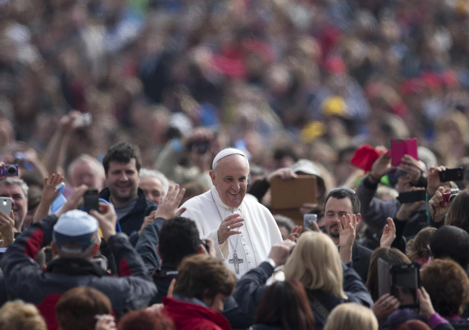 Pope Francis is cheered by the crowd as he arrives for his weekly general audience in St. Peter's Square at the Vatican, Wednesday, April 2, 2014. (AP Photo/Alessandra Tarantino)