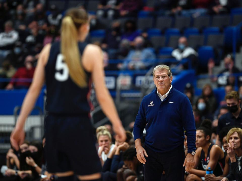 UConn head coach Geno Auriemma (right) looks at Huskies point guard Paige Bueckers.