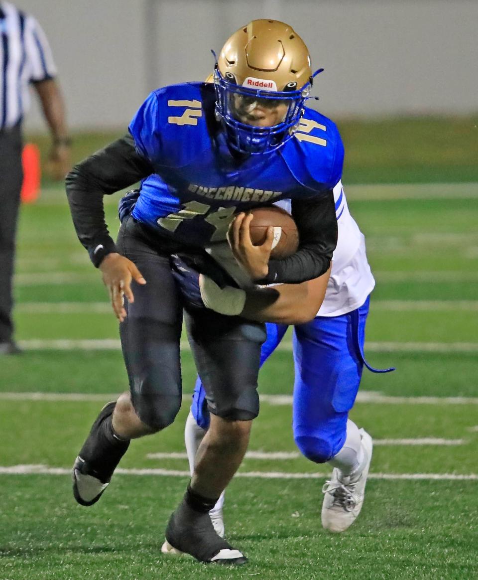 Mainland's DJ Murray runs the ball through an Osceola tackler on Thursday night. The Buccaneers won the game to move to 8-0.