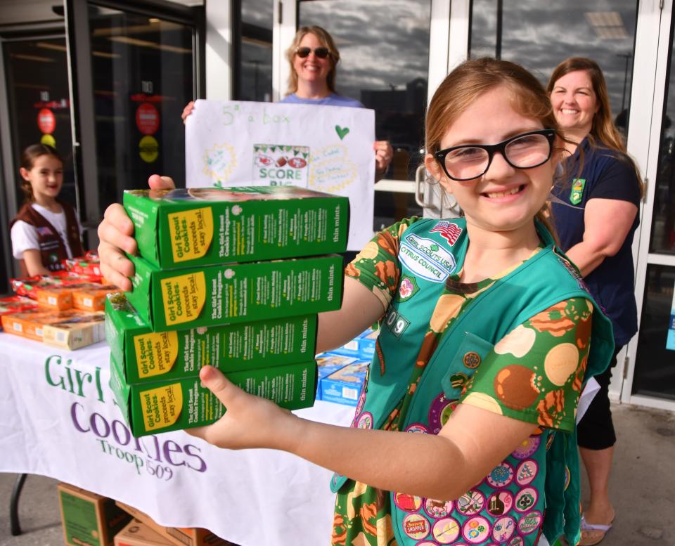 Isabella Tomerlin hands off four boxed of the coveted thin mints to a happy customer. Isabella's goal is to sell 2024 boxes of cookies this year. Girl Scout Troop 1509 was set up in front of the Melbourne beachside Winn Dixie on Eau Gallie Blvd. Saturday morning, selling Girl Scout Cookies.