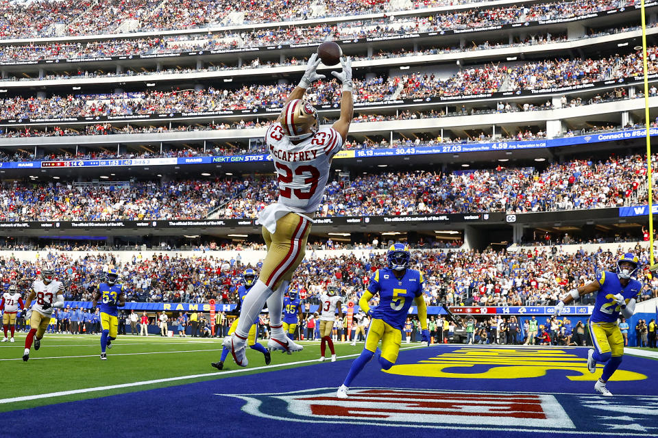 INGLEWOOD, CALIFORNIA - OCTOBER 30: Christian McCaffrey #23 of the San Francisco 49ers catches the ball for a touchdown as Jalen Ramsey #5 and Taylor Rapp #24 of the Los Angeles Rams defend during the third quarter at SoFi Stadium on October 30, 2022 in Inglewood, California. (Photo by Ronald Martinez/Getty Images)