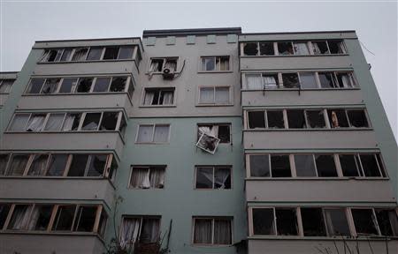 Windows of a residential building of a nearby neighbourhood are seen broken after an explosion at a Sinopec Corp oil pipeline in Huangdao, Qingdao, Shandong Province November 23, 2013. REUTERS/Mo Yat