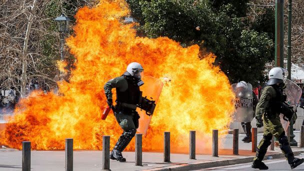 PHOTO: A riot police officer walks next to flames as clashes take place during a demonstration following the collision of two trains, near the city of Larissa, in Athens, Greece, March 5, 2023. (Alkis Konstantinidis/Reuters)