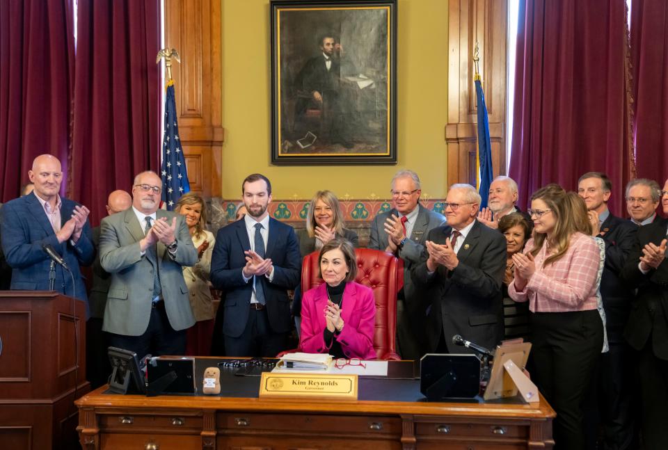 Legislators clap after Gov. Kim Reynolds signed House File 2612, Wednesday, March 27, 2024, at her office in the Iowa State Capitol.