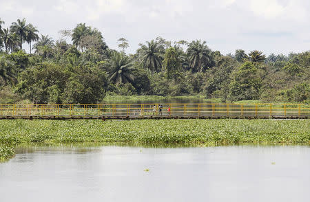 Children walk along a pedestrian bridge over a creek in Ikarama village on the outskirts of the Bayelsa state capital, Yenagoa, in Nigeria's delta region October 8, 2015. REUTERS/Akintunde Akinleye/File Photo